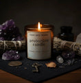 Load image into Gallery viewer, Geechee Mama protection candle with crystals and a key on a dark surface